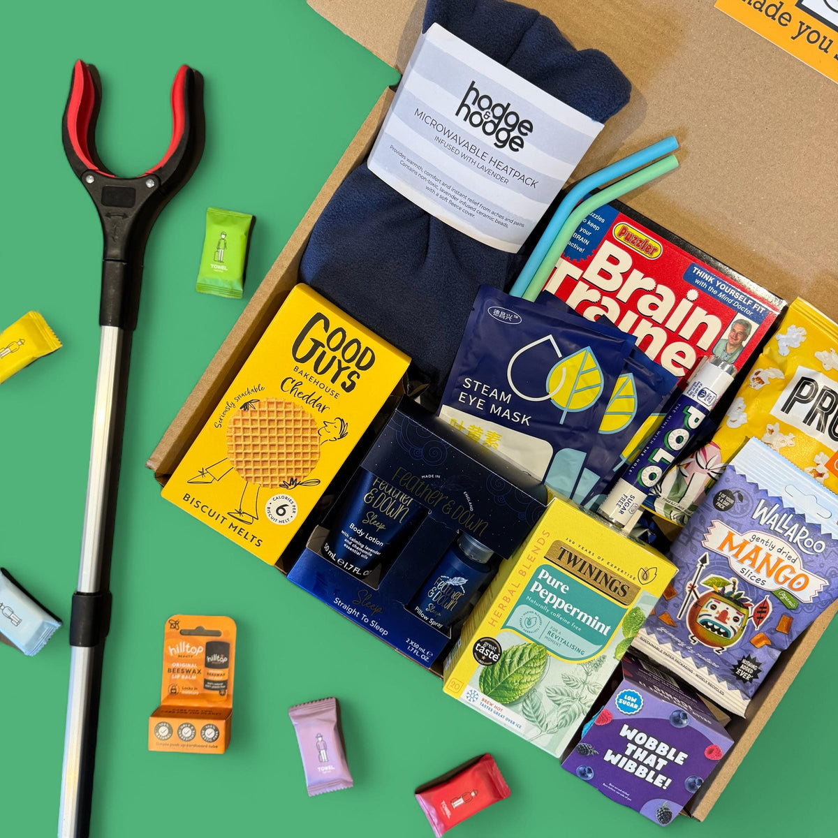 Assorted items including a tool, snacks, and magazines on a green background